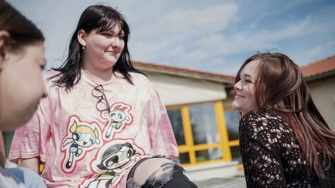 Drei Jugendliche sitzen entspannt draußen, freundschaftlicher Austausch und Gemeinschaft beim CJD.